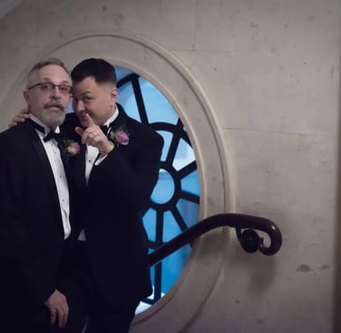 two grooms pointing at the camera