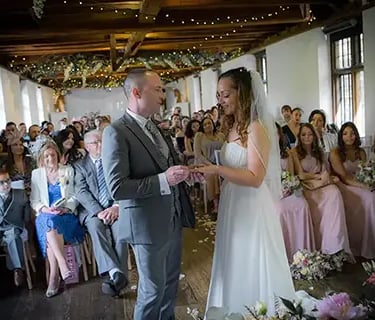 Nat and Steve standing at the front of the ceremony looking at each other