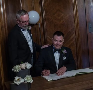 newly-weds signing the register in the paddington room at old marylebone town hall