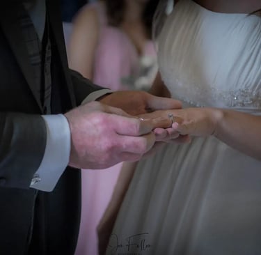 groom placing a wedding ring on his brides finger