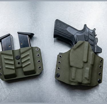 Olive drab green Kydex OWB holster with a handgun and matching double magazine pouch on a metal surface.