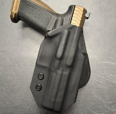 Canik TP9 pistol with gold accents secured in a black Kydex IWB holster for concealed carry.