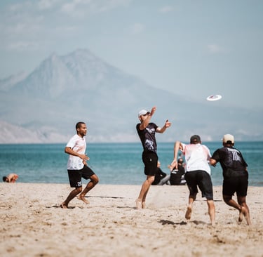 a group of people playing ultimate frisbee on a beach
