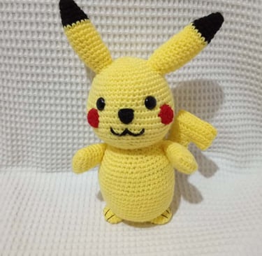 Handmade yellow crochet Pikachu amigurumi plush toy featuring iconic red cheeks and pointed ears.