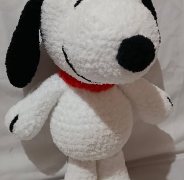 Handmade white crochet Snoopy plush toy with black ears and a red collar.