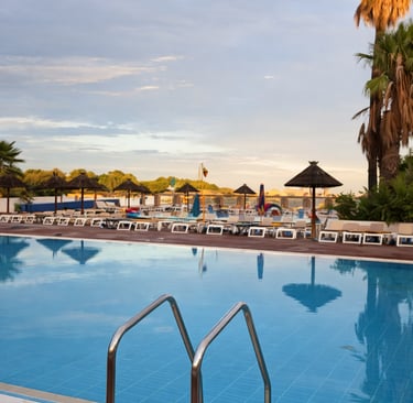 Piscine chaufée du camping Siblu Le Lac des Rêves à Lattes avec transats et palmiers