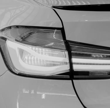 Close-up of a modern luxury car LED taillight in black and white highlighting sleek automotive design.