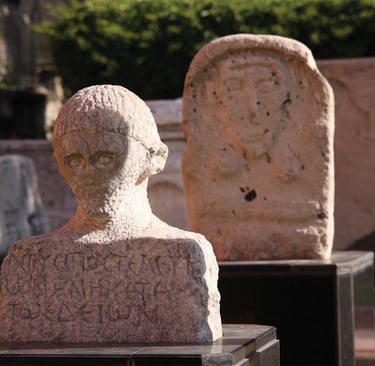 Ancient Roman stone bust and stelae with Greek inscriptions at Amasya museum exhibit.