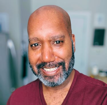 A picture of Brian, a Black person wearing a red V-neck shirt