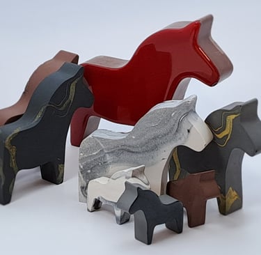 A collection of colorful handcrafted horse figurines in various sizes and colors.