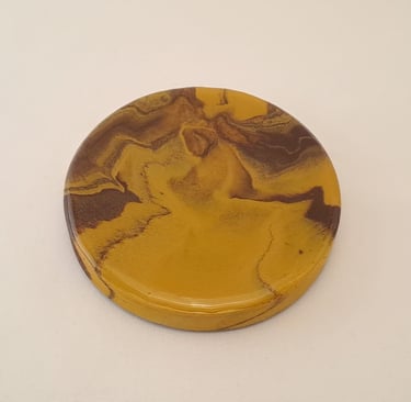 Resin and gypsum coaster in yellow featuring natural brown and tan marbled patterns.