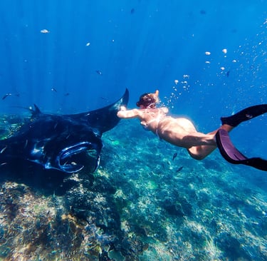 Ocean Calling Retreats, Rocío Ruiz swimming along a manta in Bali
