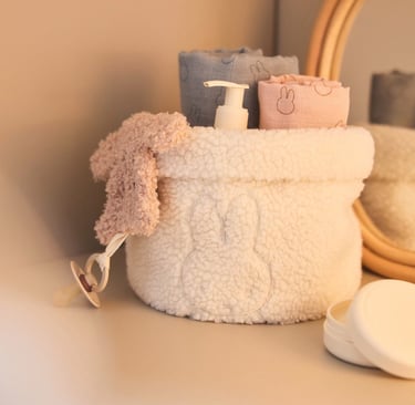 Witte fluffy Jollein Nijntje commode organizer gevuld met babyproducten op een commode
