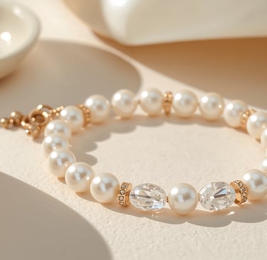 Elegant white pearl bracelet with gold spacers and crystal accents on a cream background.