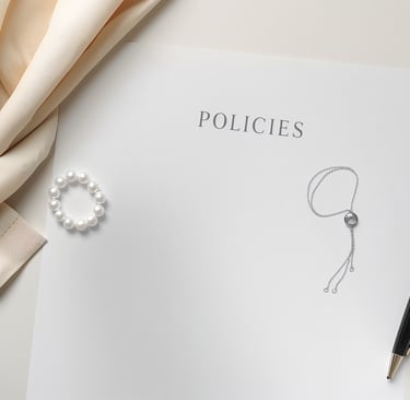 A business policy document on a desk with elegant jewelry, a black pen, and silk fabric.