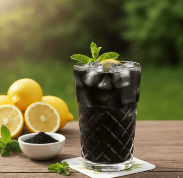 Verre de limonade au charbon garni avec fuille de menthe et rondelles de citron sur table avec les i