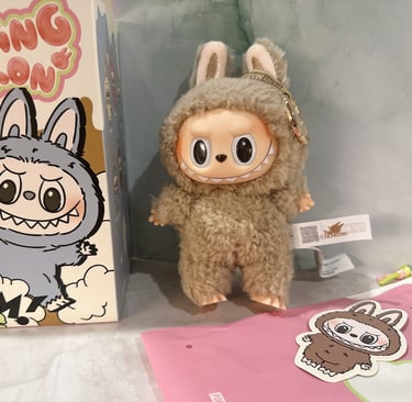 Pop Mart Labubu Exciting Macaron plush doll standing next to its collectible blind box packaging.