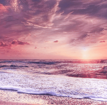 a sunset over a beach with waves crashing in the background