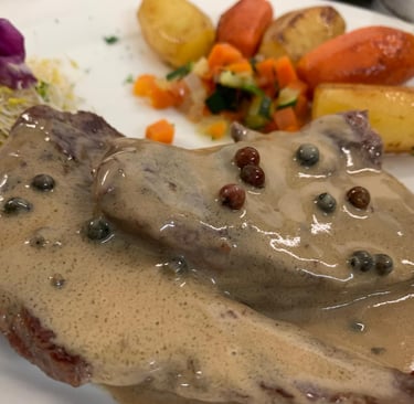 Solomillo de cerdo, salsa a la pimienta, patatas fritas y ensalada