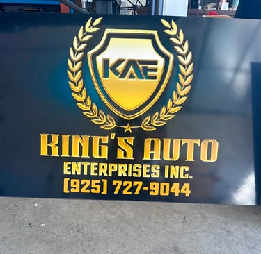 Custom gold and black King's Auto Enterprises Inc. business sign with 3D logo and contact phone number.