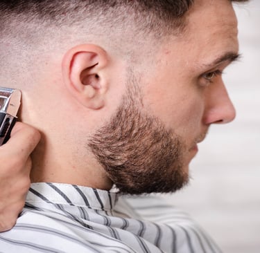 Barber giving a sharp skin fade haircut at a men's barber shop in Calgary AB