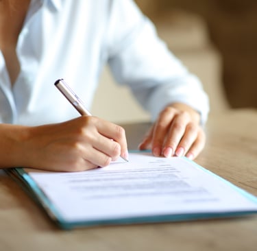 Woman signs court form with pen