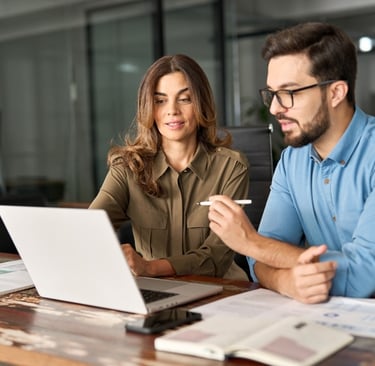Professional man and woman sit at a table in a meeting room