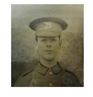 Vintage black and white portrait of a young soldier wearing a formal military uniform and peaked cap.
