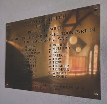 A brass memorial plaque at St Mary's Church, Harley, honoring local men who served in the 1914-18 Great War.