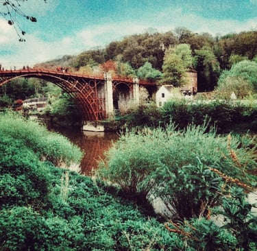 The historic Iron Bridge over the River Severn in Shropshire surrounded by lush green trees.