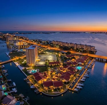 Aerial view of luxury waterfront condos and a marina at sunset in Clearwater, Florida.