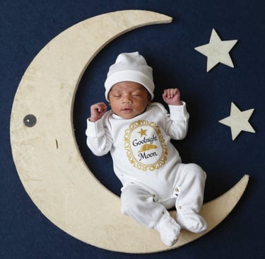 two imageNewborn baby sleeping on a handmade moon prop with stars for a celestial-themed photoshoot.