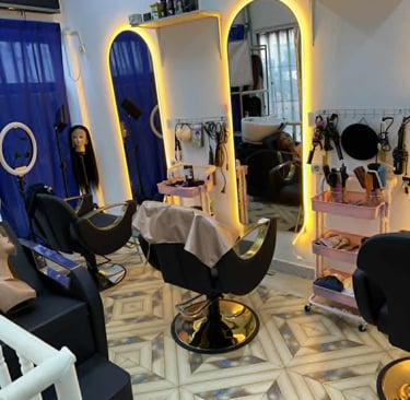 Interior moderno de salão de beleza com espelhos iluminados e cadeiras de atendimento.