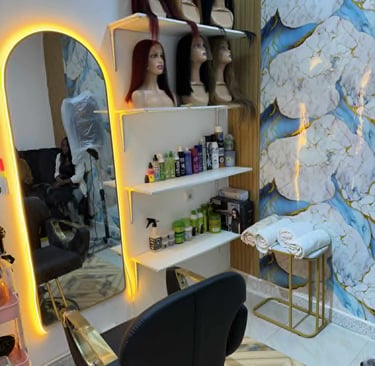 Área interna de salão de beleza profissional com cadeiras e espelhos iluminados