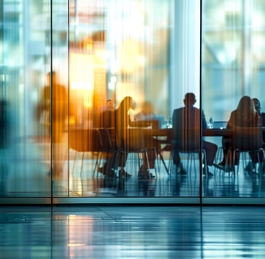 Blurred silhouettes of business professionals in a modern glass conference room for a corporate meeting.
