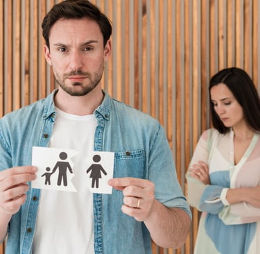 Homme tenant une image d'une familledéchirée avecune femme triste en arriere plan