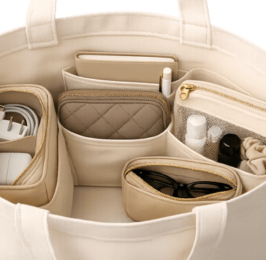 Organized canvas tote bag with beige inserts for tech cables, sunglasses, and toiletries.