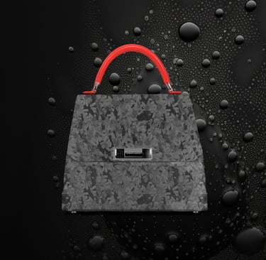 Elegant grey floral pattern designer handbag with a vibrant red handle on a water-droplet background.