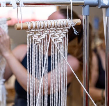 Estudiante realizando pieza sobre marco metálico en nuestro taller de macramé.