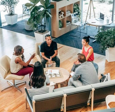 Small group meeting in a modern workspace discussing business strategy.