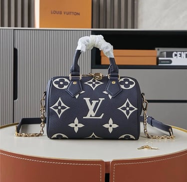Navy blue Louis Vuitton Speedy Bandouliere bag with white giant monogram print and gold chain strap.