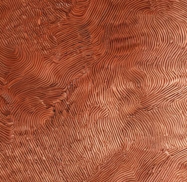 Artisan polishing a copper water filter, highlighting its smooth, warm finish.