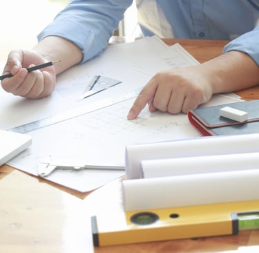 Inventor reviewing patent documents and technical drawings while preparing for the patent process