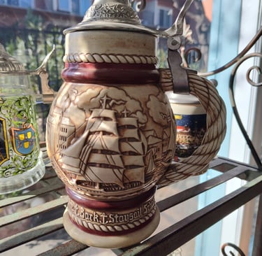 a beer stein with a ship on it