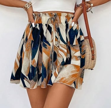 Woman wearing a high-waisted floral mini skirt with a white crop top and straw crossbody bag.