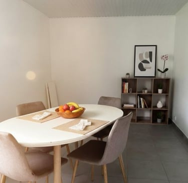 Coin repas lumineux avec table ronde et décoration moderne – location saisonnière à Ducos Martinique