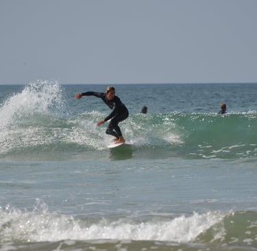 a man in a wetsuit surfing on a wave