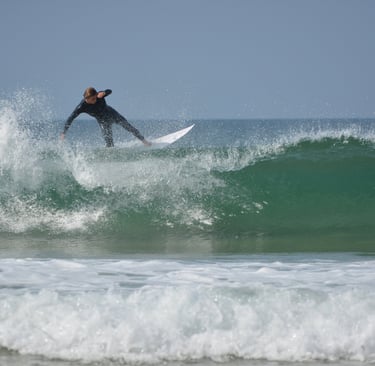 a man in a wetsuit surfing on a wave
