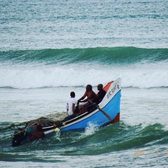 a group of people in a boat on a wave