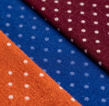 A boutique owner flipping through the premium fabric sample folder under soft lighting.